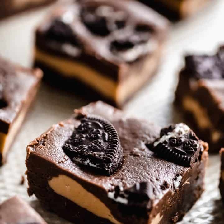 squares of chocolate fudge with a swirl of peanut fudge and topped with oreos sitting side by side each other