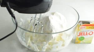 mixing cool whip in a bowl with cream cheese