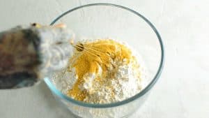 Mixing flour and seasoning salt in a glass bowl