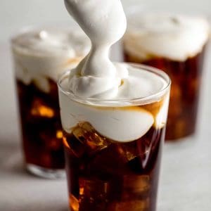 3 glasses filled with iced coffee topped with fluffy whipped cream cheese foam