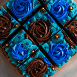 Squares of dr pepper brownies frosted with beautiful blue frosting of rosettes and stars.