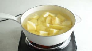 potato chunks in a white pan covered in water