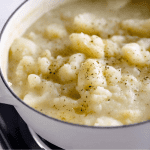 Large white potato with thick stewed potatoes, salt and pepper