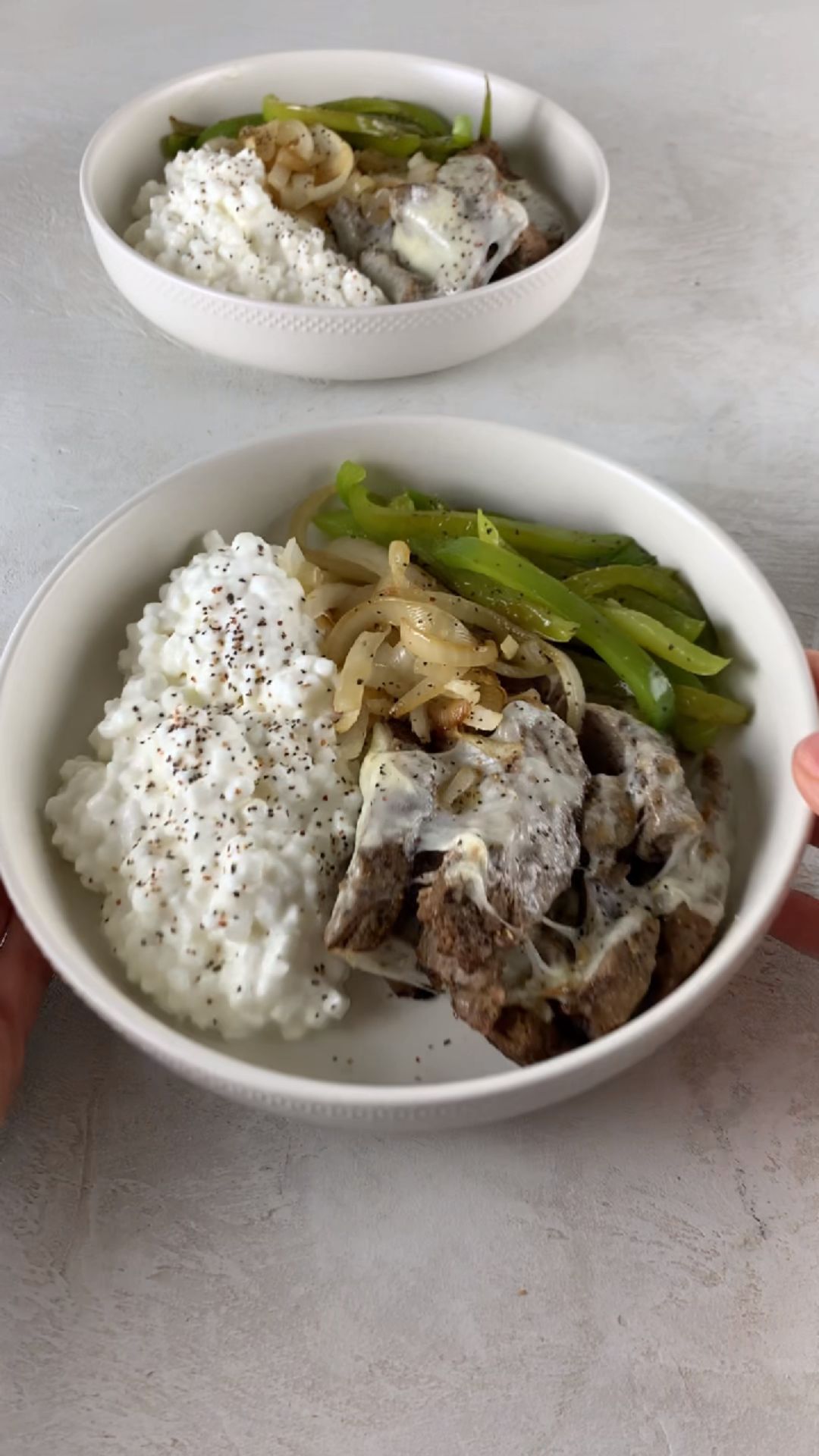 high-protein philly cheesesteak cottage cheese bowl with steak bites, melted provolone, peppers, onions, and cottage cheese