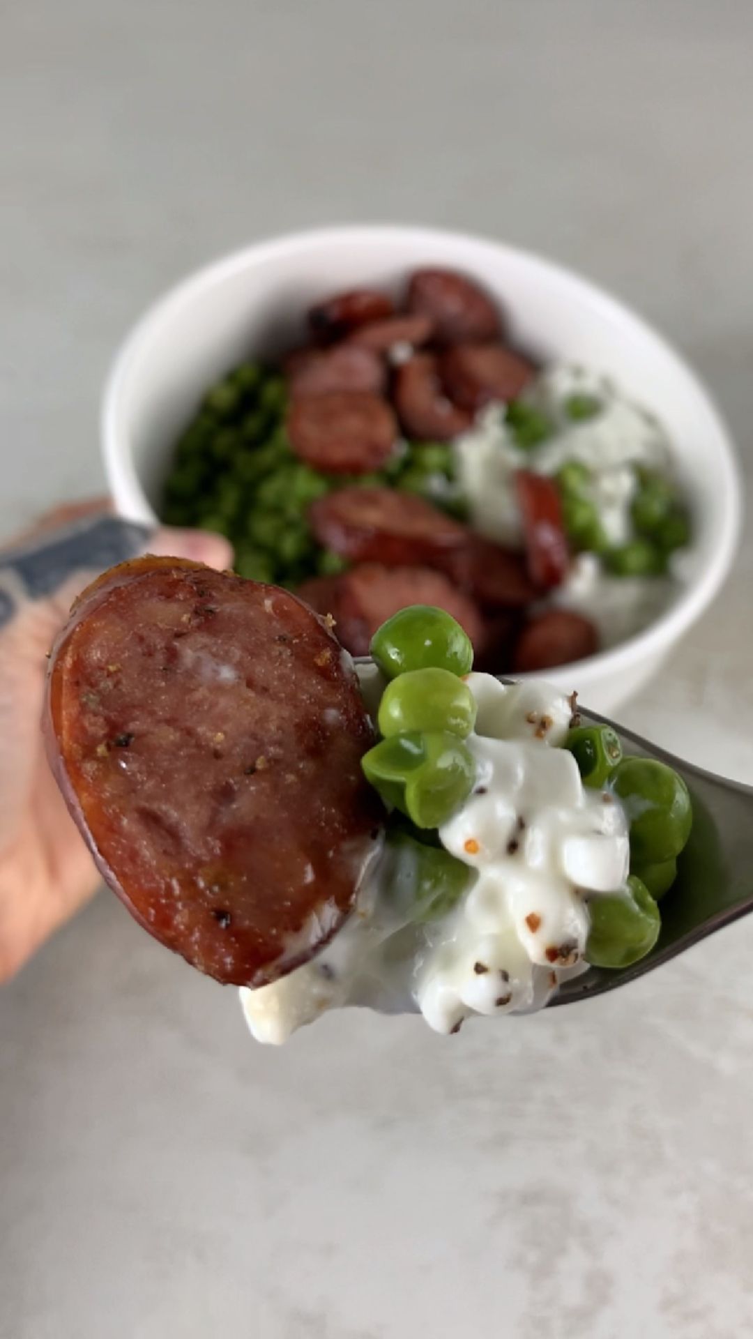 high-protein cottage cheese bowl with sliced sausage and green peas