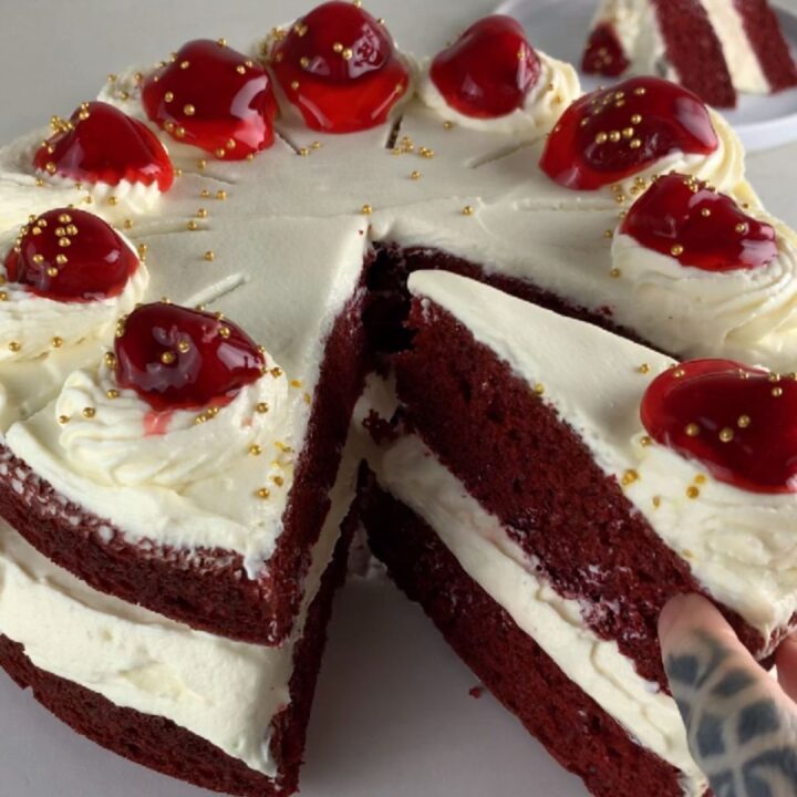 sliced two-layer red velvet protein cake with thick frosting (box mix hack)
